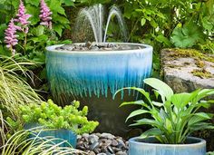 there are many plants in the garden with water coming out of their tops and flowing from them