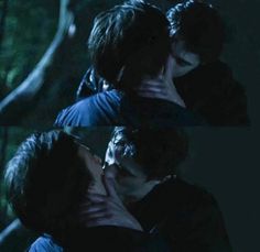 two young men are kissing each other in the dark forest, one is holding his head