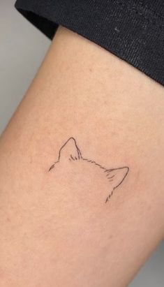 a woman's thigh with a small tattoo of a cat on the back of her leg