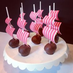 there are chocolates in the shape of a boat on top of a white cake