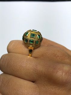 The Weddington Vintage Modernist Emerald Bombe Ring. The ring is bezel set with square emerald cut natural emeralds throughout a bombe top which is finished with a textured almost Florentine finish. The bezels are polished and the emeralds are slightly raised off the bombe top. The estimated total emerald weight by measurement is 1.50 carats. The ring is an instant classic in the modernist movement. The ring is crafted in 18 karat yellow gold and is currently a finger size 6 1/2 yet can be adjus Gold Emerald Ring In Art Deco Style, Unique Hallmarked Emerald Ring, Unique Green Emerald Ring With Bezel Setting, Gold Art Deco Emerald Ring, Bombe Ring, Natural Emerald, Bezel Setting, Emerald Cut, Turquoise Ring