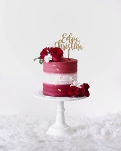 a red and white cake with gold lettering on top