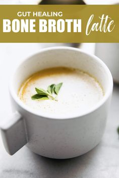 a white bowl filled with broth and garnished with green leaves