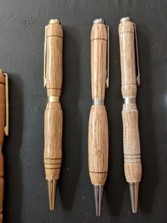 four wooden pens lined up against a black wall