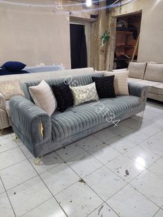 a couch and chair in a room with white tile flooring on the ground,