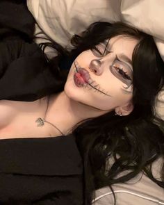 a woman with makeup on laying in bed