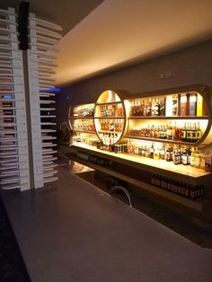 a bar with several bottles on it and lights behind the counter in front of them