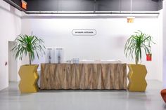 two planters sitting on top of a wooden table next to each other in front of a white wall