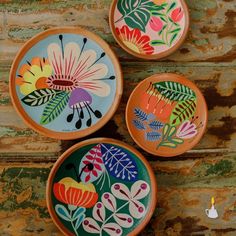 three colorful plates with flowers painted on them