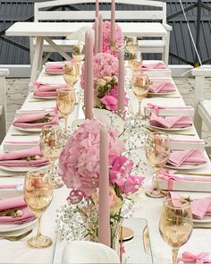 the table is set with pink flowers and candles