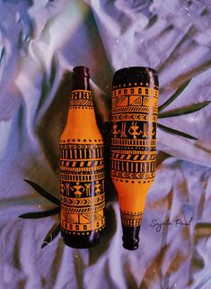 two orange vases sitting next to each other on a sheet