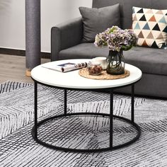 a living room with a gray couch and white coffee table on top of a rug