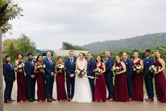 a group of people standing next to each other in front of some trees and bushes