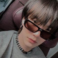 a woman with sunglasses on her head sitting in the back seat of a car and looking at the camera