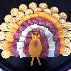 a turkey shaped meat and cheese platter with crackers in the shape of circles