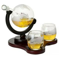 Globe Decanter with Ship Sculpture and 2 Globe Tumblers Embrace your sense of adventure, love of travel, and enjoyment of spirits with this stunning, hand-crafted, lead-free glass decanter. An artistically detailed antique ship is encased in the decanter, with an etched globe map on the glass and tumblers. Color: Clear. Whiskey Gift Set, Vodka Gifts, Wine Purse, Whiskey Set, Liquor Dispenser, Whiskey Decanter Set, Whiskey Lover Gifts, Whiskey Stones, Mahogany Stain