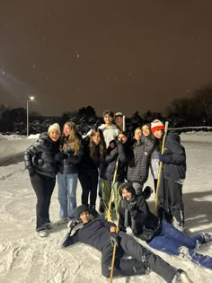 a group of people standing and laying in the snow