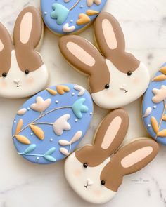 decorated cookies with chocolate and white frosting on a marble counter top, including two bunny ears