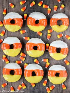 halloween candy donuts with orange and white frosting on top, surrounded by candy candies