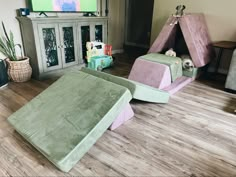 two children's beds in the middle of a living room with a tv on