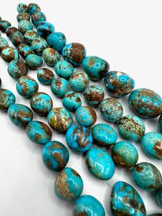 several turquoise and brown beads on a white surface