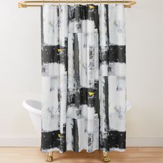 a black and white shower curtain with yellow flowers on the bottom, in front of a bathtub