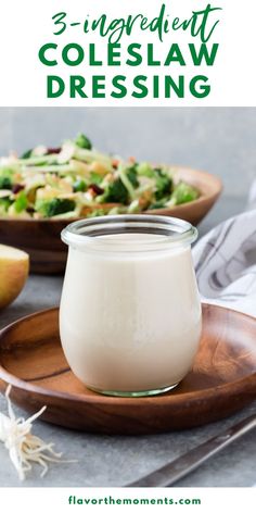 three ingredient coleslaw dressing in a glass jar on a wooden plate next to a bowl of broccoli and an apple