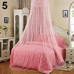 a bed with a pink canopy over it in a bedroom next to a white dresser