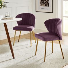 two purple chairs sitting on top of a white rug