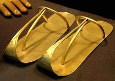 a pair of gold sandals sitting on top of a table