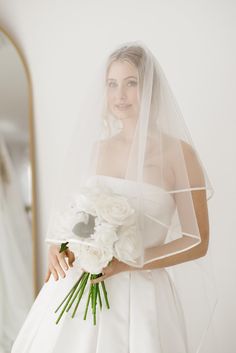 a woman in a wedding dress holding a bouquet