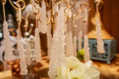 a vase filled with white flowers sitting on top of a table next to candles and chandeliers