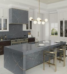 a large kitchen with marble counter tops and white cabinets, along with bar stools