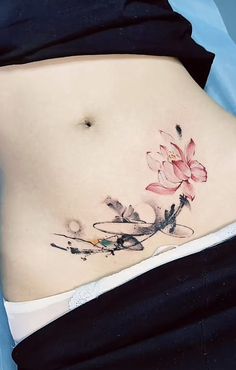 a woman's stomach with a flower tattoo on her belly and the bottom part of her stomach