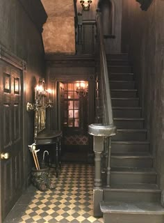 an old house with black and white checkered flooring, chandelier, and stairs