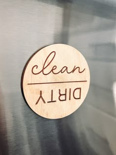 a close up of a metal surface with a sign that says clean and dishwasher