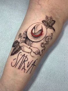 a tattoo on the leg of a person with a hat and words written in black ink