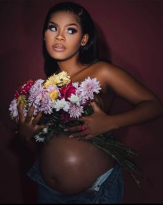 a pregnant woman holding flowers in her belly