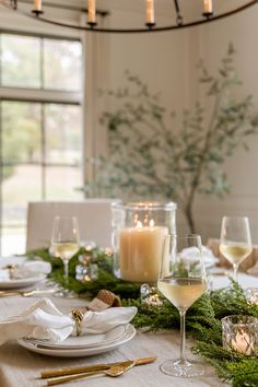 the table is set with candles, plates and glasses