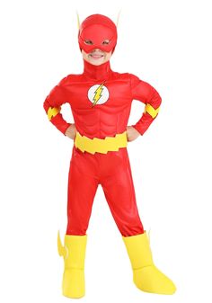 a young boy in a red and yellow costume standing with his hands on his hips