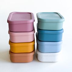 four different colored containers stacked on top of each other