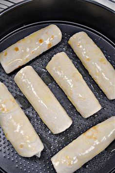 six pieces of fish cooking in a frying pan