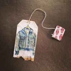 an ornament with a shirt on it next to a tag