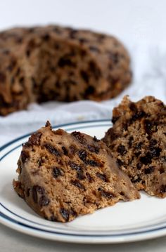 a piece of cake on a plate next to a muffin that has been cut in half