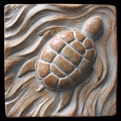 a carved tile with a turtle on it