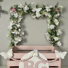 a wooden box with flowers and butterflies on it that says b & g in the center