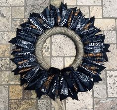 a wreath made out of black and white candy wrappers sitting on top of a stone floor