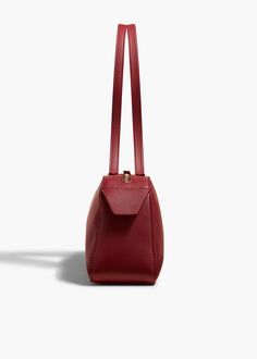 A refined and elongated silhouette that unites decisive lines with soft curves. Topped by sleek, doubled straps and a custom zipper. Suede-lined interior. Sleek Smooth Grain Shoulder Bag, Burgundy Evening Shoulder Bag With Leather Lining, Evening Burgundy Shoulder Bag With Leather Lining, Elegant Burgundy Bag With Zipper Closure, Chic Red Shoulder Bag With Smooth Grain, Evening Structured Shoulder Bag With Smooth Grain, Classic Burgundy Shoulder Bag With Zipper Closure, Classic Burgundy Bag With Zipper Closure, Chic Burgundy Shoulder Bag With Leather Lining