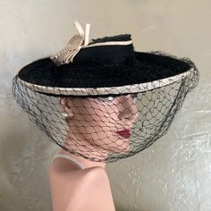 This Is A Showstopper Black Straw Wide Brim Tilt Hat From The 1930's. The Small Crown Is Flat At The Top, And Is Surrounded By A Black And Cream Colored Grosgrain Band. The Wide Brim Is Also Edged In The Black/Cream Grosgrain. At The Top Side Of The Brim There Is A Most Creative Cream Colored Grosgrain Trim That Looks Like A Butterfly. Please Note That There Is A Very Small Soiled Area At The Bottom Left "Wing" Of The Butterfly Trim, As Shown In The Last Photo. A Magnificent Full Black Veil Completes This Stunning Look. There Are 2 Grosgrain Bands Joined By An Elastic Ring Attached To The Back To Hold This Beautiful Hat In Place. Tilt Hats Were Popular In The 1930s And 1940s. They Were Worn Black Vintage Cloche Hat With Wide Brim, Vintage Black Wide Brim Top Hat, Vintage Washed Black Hat With Curved Brim, Vintage Black Costume Hat With Curved Brim, Black Vintage Cloche Hat With Curved Brim, Elastic Rings, 30s Fashion, Black Veil, Black Cream