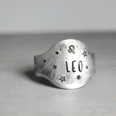 a silver ring with the word leo written on it's side and stars in the middle